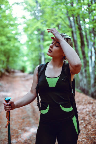 istock Female Wiping Sweat From Hiking Through Forest 1226368397