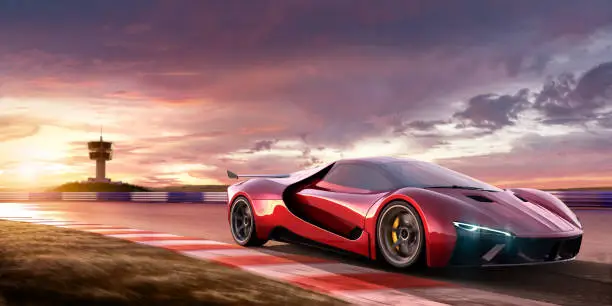 A close up image of a generic red sports car moving at high speed on a racetrack at beautiful dramatic and colourful sky at sunset. The location is fictional, and observation tower is visible in the background. Selective focus, with car in focus and motion blur on foreground.