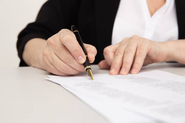 istock Female office worker writing on paper documents by pen. 1226368901