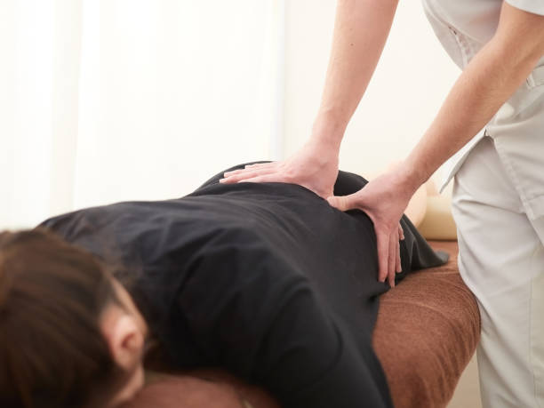 японка получает массаж тазобедренного сустава в клинике seitai - shiatsu beauty relaxation care стоковые фото и изображения