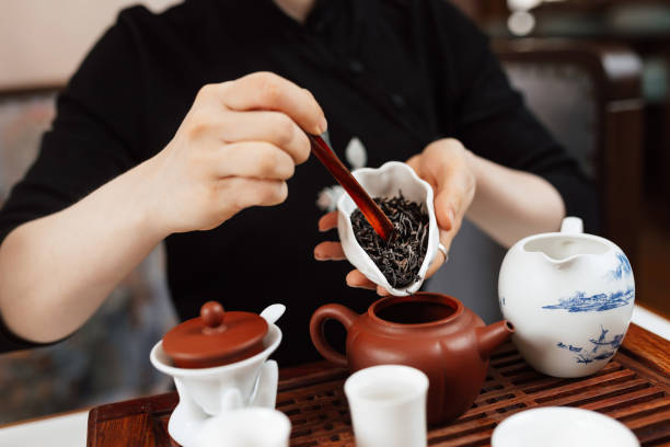istock Chinese tea ceremony. Girl pours tea leaf into a teapot 1226374473