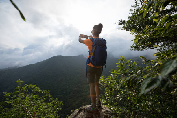 istock Successful hiker using smartphone on sunrise mountain top cliff edge 1226374937