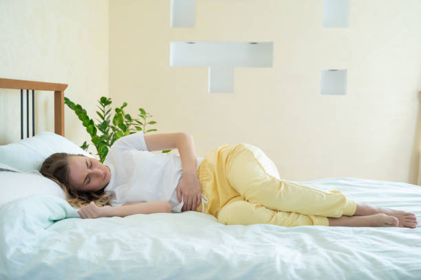 istock Woman suffering from abdominal pain while lying on bed at home 1226377435