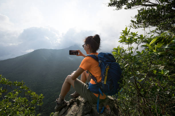 istock Successful hiker using smartphone on sunrise mountain top cliff edge 1226377589