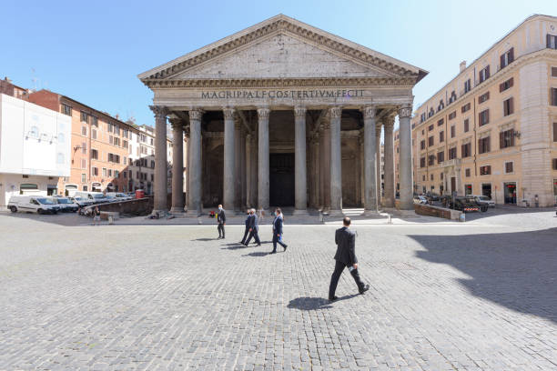 Men wearing face masks in front of the Pantheon, Rome, Italy Rome, Italy - 19 May 2020: Men in business suits wearing face masks walk in group across the otherwise mostly empty Pantheon square in Rome, Italy. The end of COVID-19 lockdown has not brought back the usual tourist crowds to the popular landmark. ancient rome photos stock pictures, royalty-free photos & images
