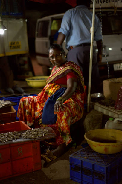 Anjun, India - February 03th, 2019: A woman sells fresh shrimp and fish at a night market in India, Goa.