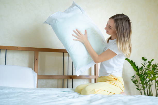 istock Woman holding a pillow while sitting on her bed 1226379109