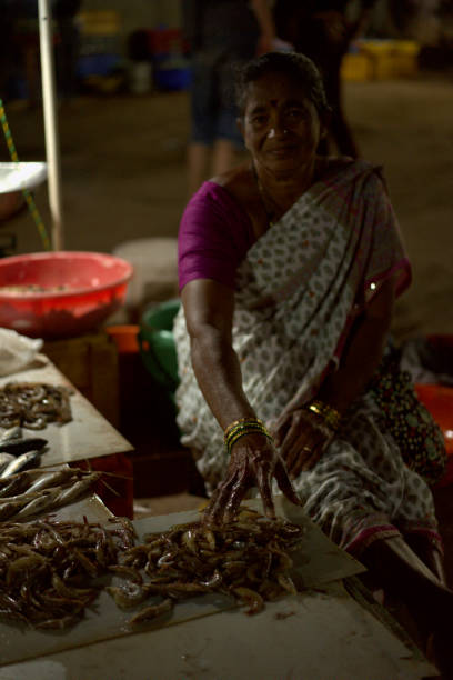 Anjun, India - February 03th, 2019: A woman sells fresh shrimp and fish at a night market in India, Goa.