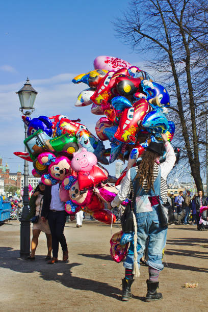 Frankfurt, Germany - Rear view of a balloon seller with a large collection of helium balloons featuring various characters, on a street in Frankfurt.