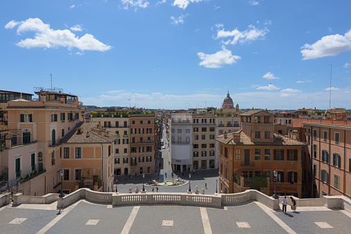 Rome, Italy - 19 May 2020: Three tourists take pictures on the popular Spanish Steps tourist spot, otherwise empty in the middle of the day. The usual traveller crowds have not yet returned to Rome, even after the end of the COVID-19 lockdown on May 18th in Italy