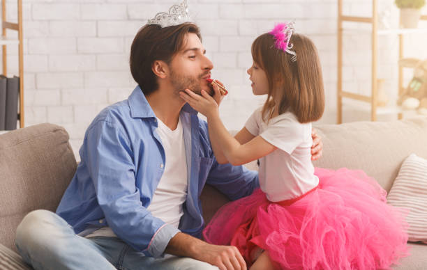 istock Cute little girl putting make up on her father 1226380773