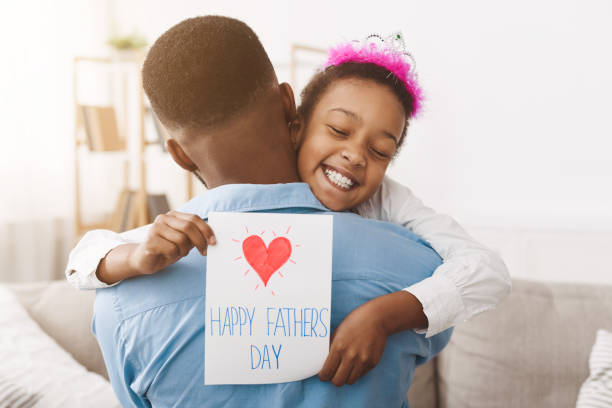 dzień ojca. ładna dziewczyna dająca tacie pocztówkę - fathers day greeting card father child zdjęcia i obrazy z banku zdjęć