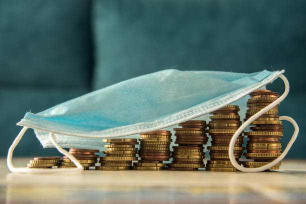 istock Stacks of coins and a protective surgical face mask 1226382692