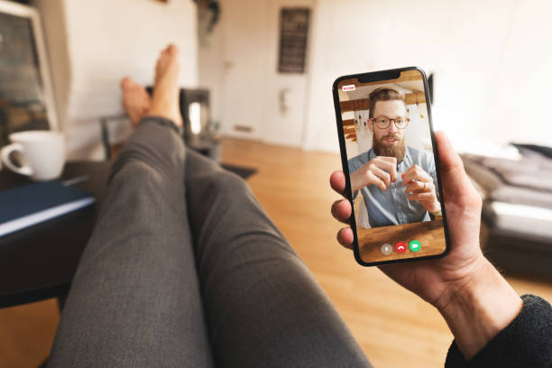 Casual video call meeting on a smartphone from home Point of view of a man that is on a video conference call with a colleague. They are calling from home during the COVID-19 pandemic. personal perspective stock pictures, royalty-free photos & images