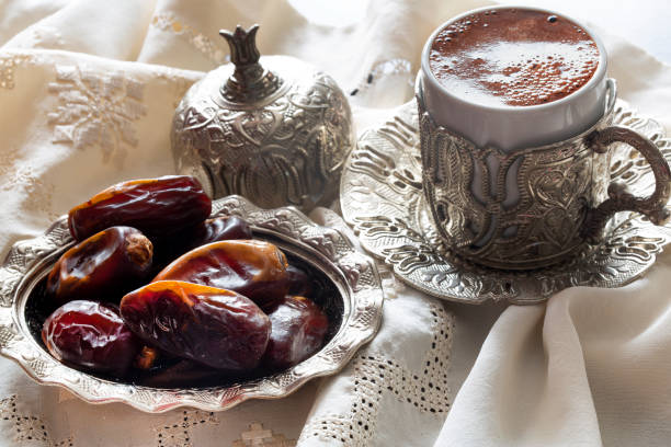 Dried dates with coffee and traditional silver serving set. Feast of Ramadan. stock photo
