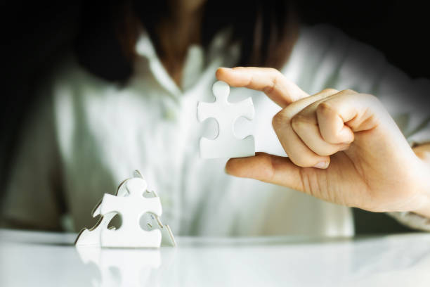 istock Hands of working woman connecting jigsaw puzzle. 1226384265