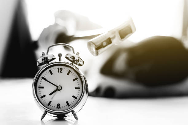 Alarm clock with woman on your bed , waking up at morning with sunlight.