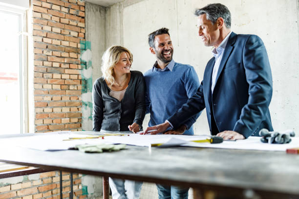 istock Happy couple talking to architect about blueprints at construction site. 1226384785