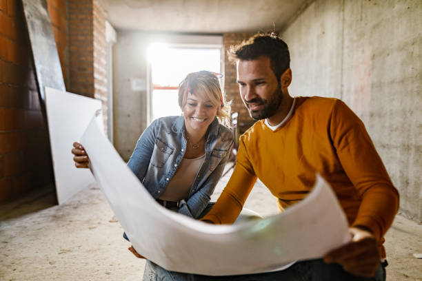 istock Happy couple analyzing plans at their renovating apartment. 1226384960