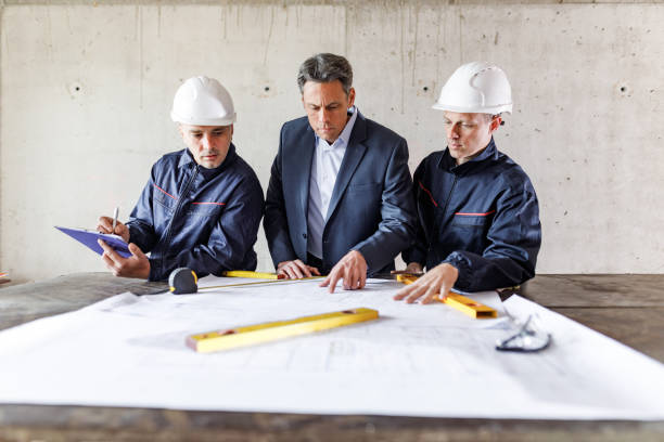 istock Architect and manual workers examining housing project at construction site. 1226385050