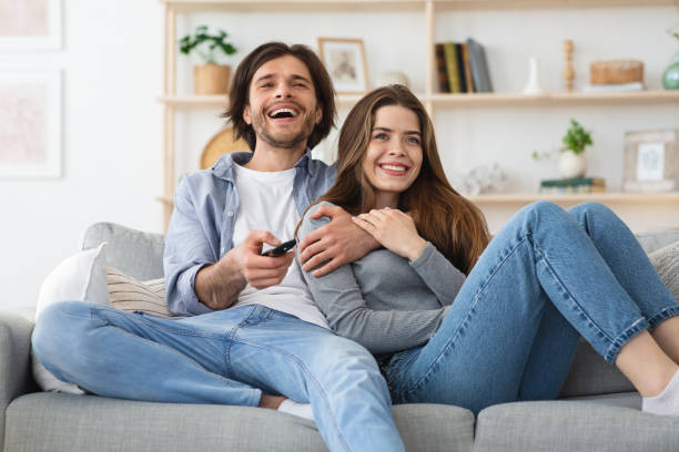istock Man and woman spending weekend together, watching TV 1226385090