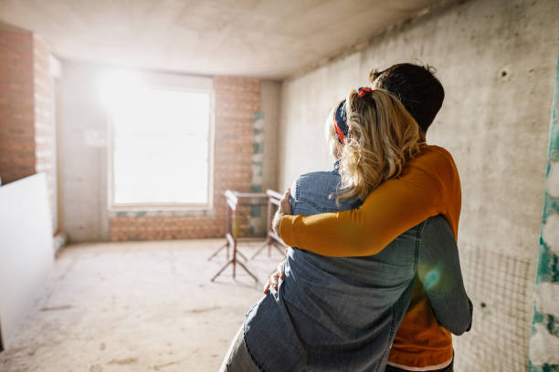 This is going to be our new home! back view of an embraced couple standing at their renovating apartment. Copy space. rebuilding stock pictures, royalty-free photos & images