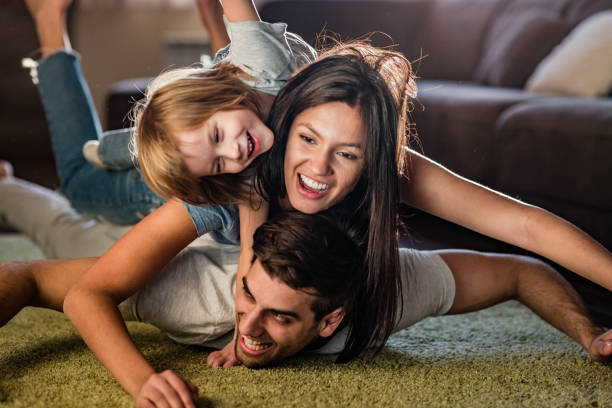 istock Playful family having fun while making human pyramid at home. 1226386477