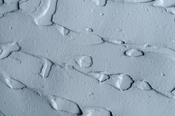 istock Gray bentonite facial clay (alginate mask, face cream, body wrap) texture close up, selective focus. Abstract background with brush strokes. 1226388598