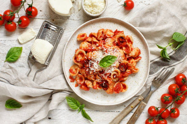süditalienische pasta orecchiette mit tomatensauce und cacioricotta-käse - orecchiette stock-fotos und bilder