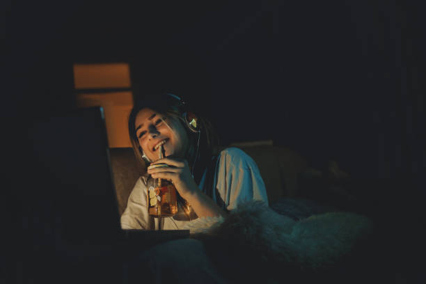 Teenager girl watching online movie Single woman watching online movie in the night sitting on a couch in the living room at home free girl download stock pictures, royalty-free photos & images