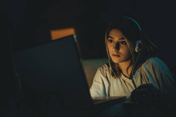 Teenager girl watching online movie Single woman watching online movie in the night sitting on a couch in the living room at home free girl download stock pictures, royalty-free photos & images