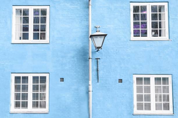 istock Light blue wall, street lantern and four white windows 1226390792