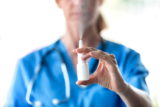 médico femenino con spray o gotas nasales para el tratamiento de secreción nasal sobre fondo blanco. - medical equipment stethoscope hospital blue fotografías e imágenes de stock