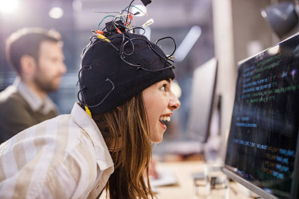 Profile view of crazy female programmer staring and analyzing codes on desktop PC in the office. There is a person in the background.