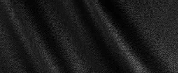istock black leather background wavy waves banner. texture abstract close up, surface studio photography. copy space, mockup empty space banner 1226391714