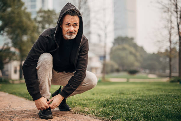 istock Mature man runner tying sneakers in public park 1226392124