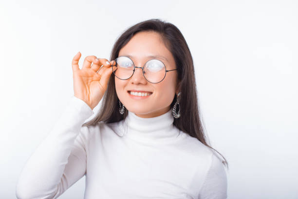 istock Smiling girl is daydreaming while wearing glasses over white background. 1226392858