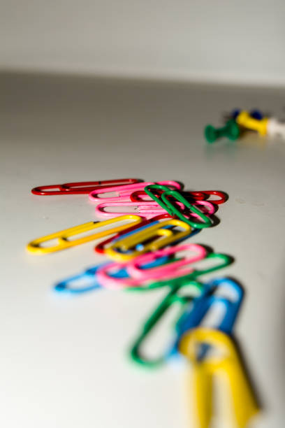 Push pins and paper clips in different colors isolated on white background.