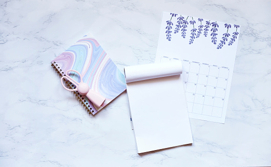 Flat lay composition with calendar and notebook on marble surface table