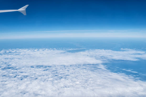 atmosphere, stratosphere, air. sky and clouds seen from plane window. cloudscape, weather, nature. wanderlust, adventure, discovery. vacation, travel, trip - earth stratosphere space planet imagens e fotografias de stock