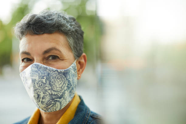 istock One midle aged woman wearing a protective mask and smiling 1226400409