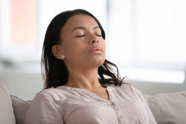 calm african woman resting closed eyes breathing fresh humidified air - air freshener imagens e fotografias de stock