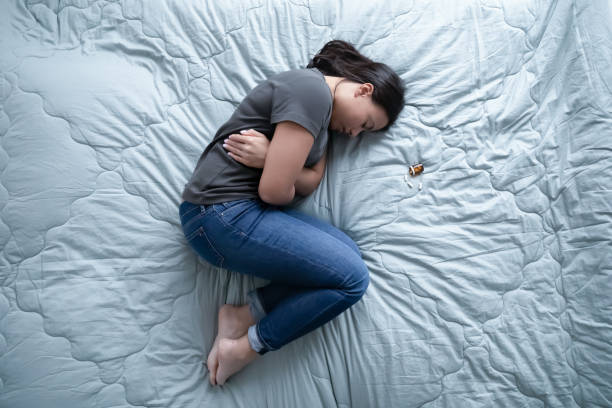 mujer acostada en la cama cerca de un montón de píldoras sobre la vista - pill human pregnancy capsule women fotografías e imágenes de stock