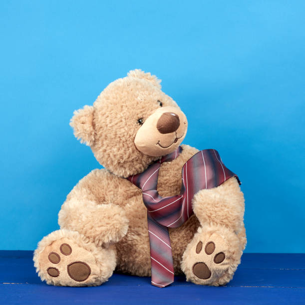 istock brown teddy bear sits on a blue wooden background 1226400954