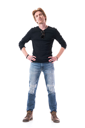 Dissatisfied young handsome red hair man with hands on hips looking at camera with suspicious. Full body length isolated on white background.