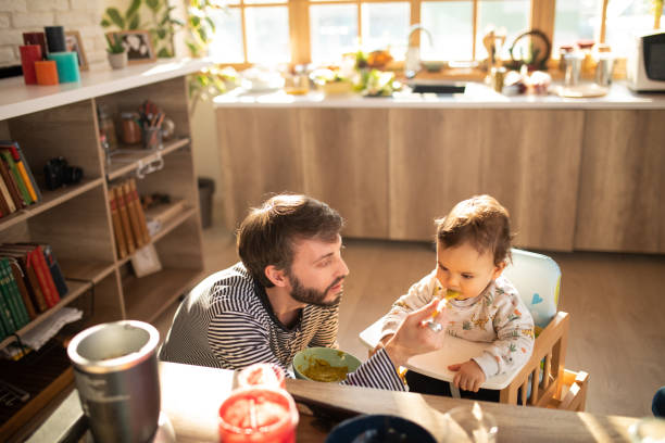 istock Single father feeding his baby boy at home 1226403400