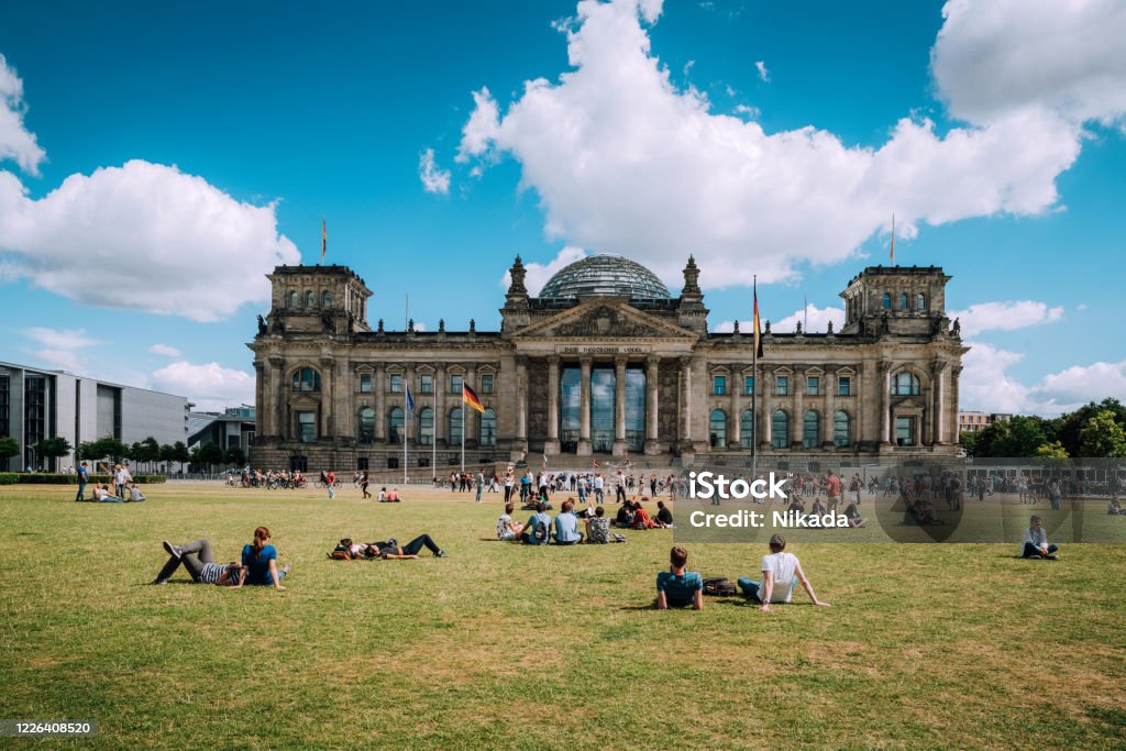 Reichstag in Berlin, Germany View of the German Parliament, called Der Reichstag. People are resting, lying on the meadow. Berlin Stock Photo