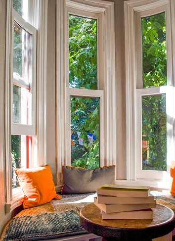 Cozy reading area/corner with long windows and green trees at the background