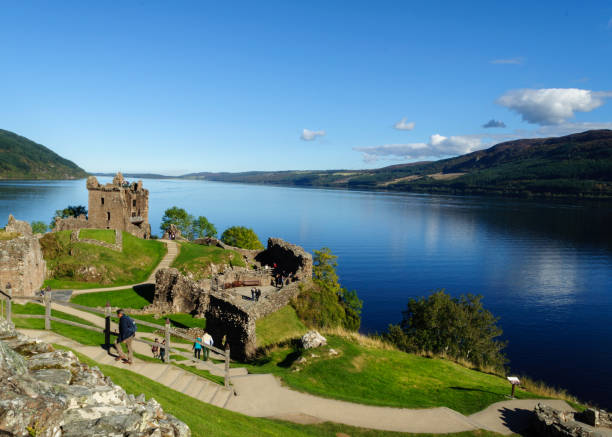 Tourists at Urquhart Castle in Scotland The castle ruins and the lake on which they stand, Loch Ness, are both very popular tourist attractions in the Scottish Highlands drumnadrochit stock pictures, royalty-free photos & images