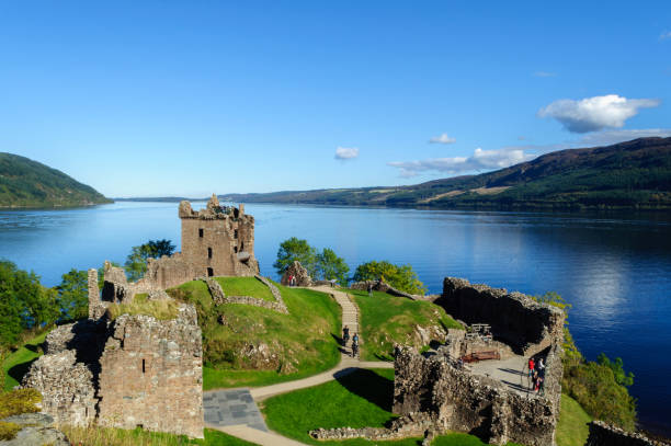 Urquhart Castle on a sunny day in Scotland The castle ruins, on the shore of Loch Ness, are a very popular tourist attraction in the Scottish Highlands drumnadrochit stock pictures, royalty-free photos & images